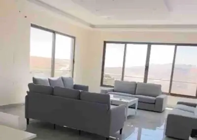 a living room with couches and tables and windows at Farmhouse with Pool and Breathtaking Views in Amman