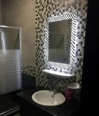 a bathroom with a sink and a mirror at شقق المومني in Amman