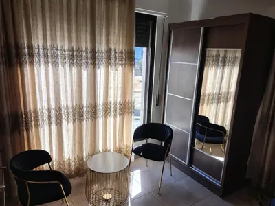 a room with chairs and a table and a window at شقق المومني in Amman