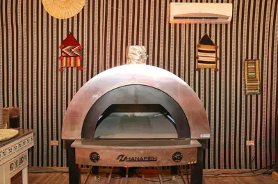 a pizza oven in a room with a wall at Imagination Luxury Camp in Disah