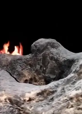 a close up of a rock with a fire in the background at Petra Anas House in Wadi Musa