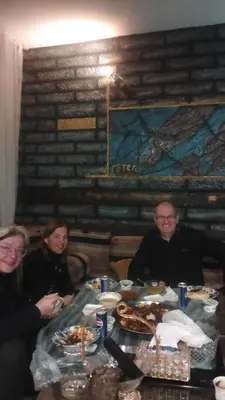 a group of people sitting at a table with food at Petra Anas House in Wadi Musa