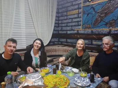 a group of people sitting around a table eating food at Petra Anas House in Wadi Musa