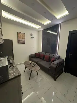 a living room with a couch and a table at شقة فاخرة - غرفتين نوم وصالة صغيرة مع بلكونة Modern 2 Bedrooms Appartment with Balcony in Amman