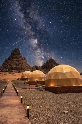 a group of tents in the desert under a starry sky at wadi rum tha moon in Wadi Rum