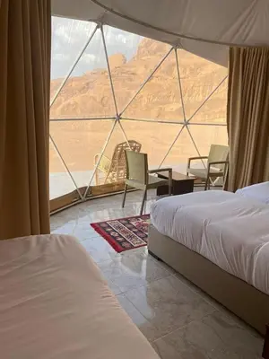 a room with two beds and a view of the desert at wadi rum tha moon in Wadi Rum