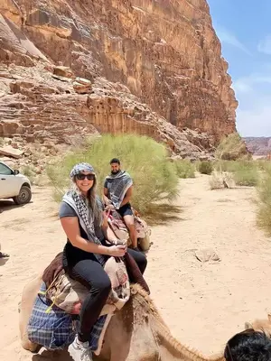 two people riding on the back of an elephant in the desert at wadi rum tha moon in Wadi Rum
