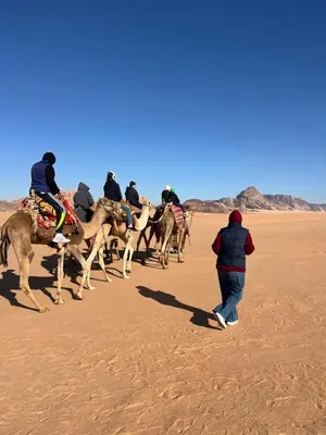 a group of people riding horses in the desert at wadi rum tha moon in Wadi Rum