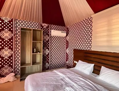 a bedroom with a bed and a red and white wall at Shebara Camp Wadi Rum in Wadi Rum