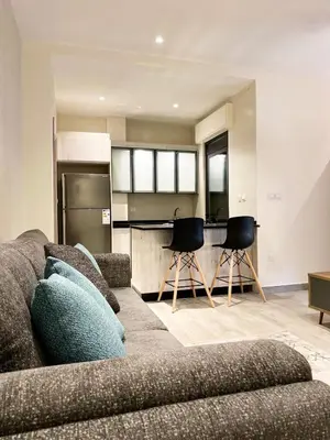 a living room with a couch and a kitchen at Odeh Residence in Aqaba