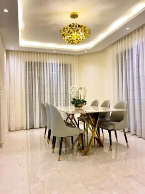 a dining room with a table and chairs and a chandelier at Odeh Residence in Aqaba
