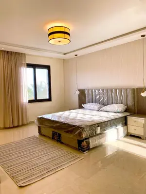 a bedroom with a large bed and a window at Odeh Residence in Aqaba