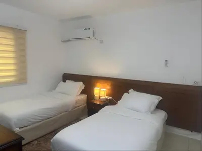 a hotel room with two beds and a night stand at Marvel Hotel Apartments in Wadi Musa