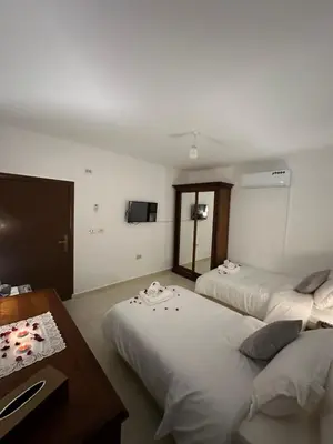 a hotel room with two beds and a table at Marvel Hotel Apartments in Wadi Musa