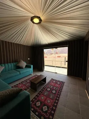 a living room with a couch and a table at Gem wadi rum camp in Wadi Rum