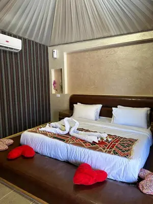 a bedroom with a large bed with red pillows on it at Gem wadi rum camp in Wadi Rum