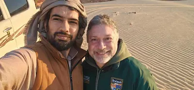 two men standing next to each other in the desert at Rum Plaza Luxury Camp in Wadi Rum