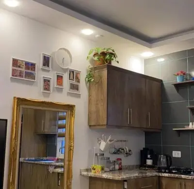 a kitchen with wooden cabinets and a counter top at Little Green Farm in Wadi Musa