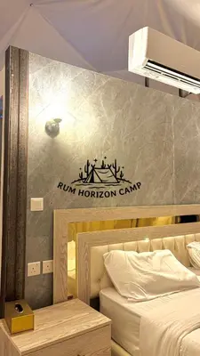 a bedroom with a bed and a sign on the wall at Rum Horizon Bubble luxury camp in Wadi Rum