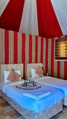 a bed in a red and white tent at Rum Horizon Bubble luxury camp in Wadi Rum