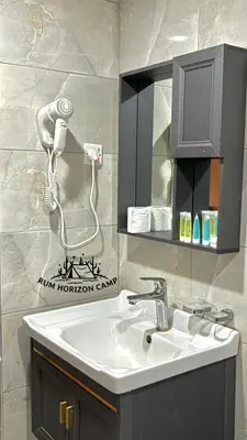 a bathroom with a sink and a hair dryer at Rum Horizon Bubble luxury camp in Wadi Rum