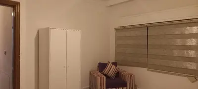 a living room with a chair and a window at Khalda Apartments for females in Amman