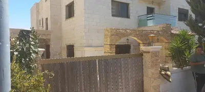 a man standing on a fence in front of a building at Khalda Apartments for females in Amman