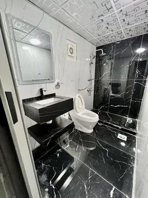 a black and white bathroom with a sink and a toilet at Wadi Rum Marina Camp in Wadi Rum