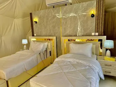 two beds sitting next to each other in a bedroom at Wadi Rum Marina Camp in Wadi Rum