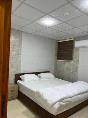 a bedroom with a large bed with white sheets at Wadi Rum Marina Camp in Wadi Rum