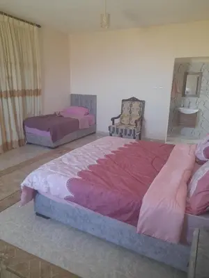 a bedroom with two beds with pink sheets on them at مزرعة الشفق in Ad Dimnah
