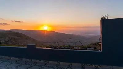 a view of the sun setting over a mountain at مزرعة الشفق in Ad Dimnah