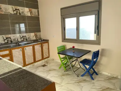 a kitchen with a table and chairs and a window at مزرعة الشفق in Ad Dimnah