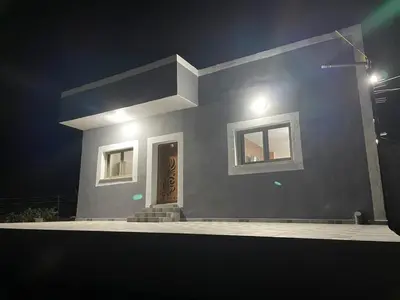 a house with two windows and a door at night at مزرعة الشفق in Ad Dimnah