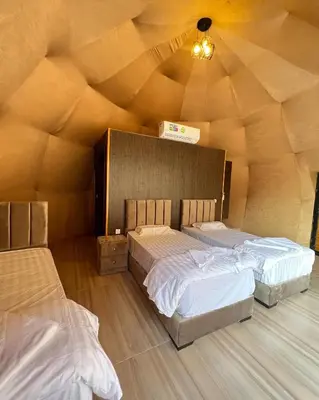 two beds in a room with a wooden ceiling at Madar Camp, Wadi Rum in Wadi Rum