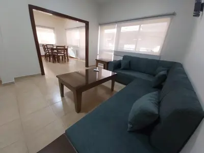 a living room with a blue couch and a table at CMK Housing in Madaba