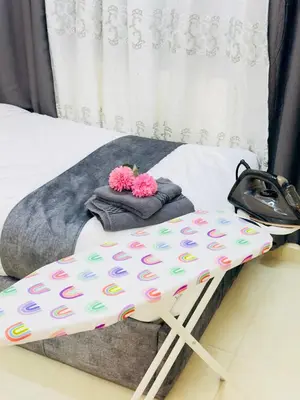 a bed with polka dot sheets and pink flowers on it at ENG-Murjan Apartment in Aqaba