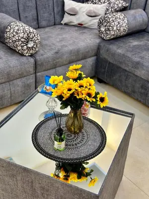 a table with a vase of yellow flowers on it at ENG-Murjan Apartment in Aqaba
