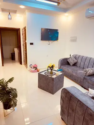 a living room with a couch and a tv on a wall at ENG-Murjan Apartment in Aqaba