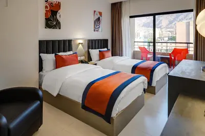 two beds in a hotel room with a balcony at The Loft hotel By FHM in Aqaba