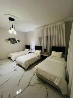 a bedroom with two beds with white sheets at Luxury 4-bedrooms apartment in Aqaba