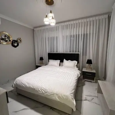 a bedroom with a large bed with white sheets at Luxury 4-bedrooms apartment in Aqaba