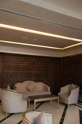 a living room with a couch and a table and chairs at Rival Hotel Amman in Amman