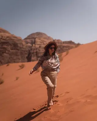 a woman walking in the desert at Wadi Rum Santa Camp in Wadi Rum