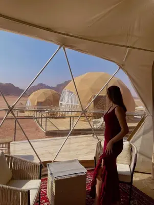 a woman standing in a tent looking out at the desert at Wadi Rum Santa Camp in Wadi Rum