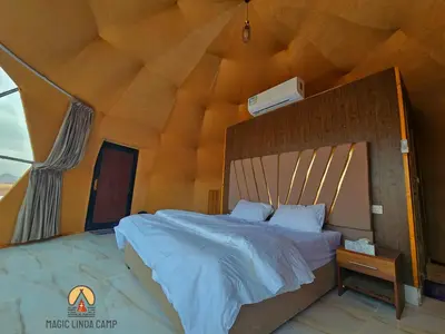 a bedroom with a large bed with a wooden ceiling at wadi rum,Linda Camp in Wadi Rum