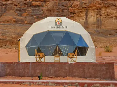 a tent in the desert with chairs in it at wadi rum,Linda Camp in Wadi Rum