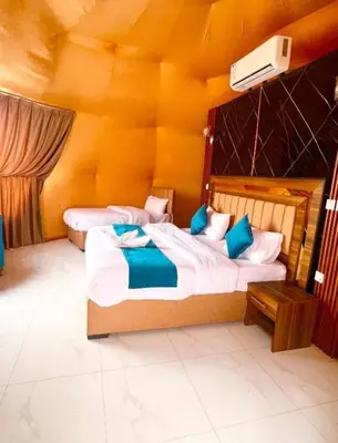 two beds in a room with yellow walls at Joker camp Wadi Rum in Disah