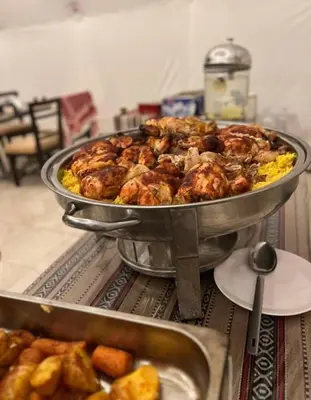 a large pan of food on a table with food at Joker camp Wadi Rum in Disah