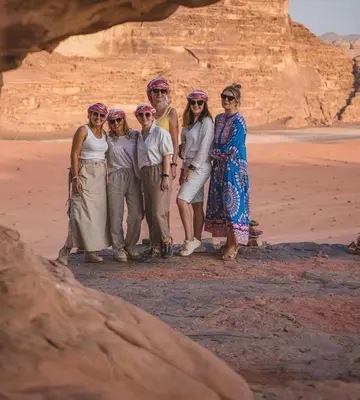 a group of people posing for a picture in the desert at Joker camp Wadi Rum in Disah